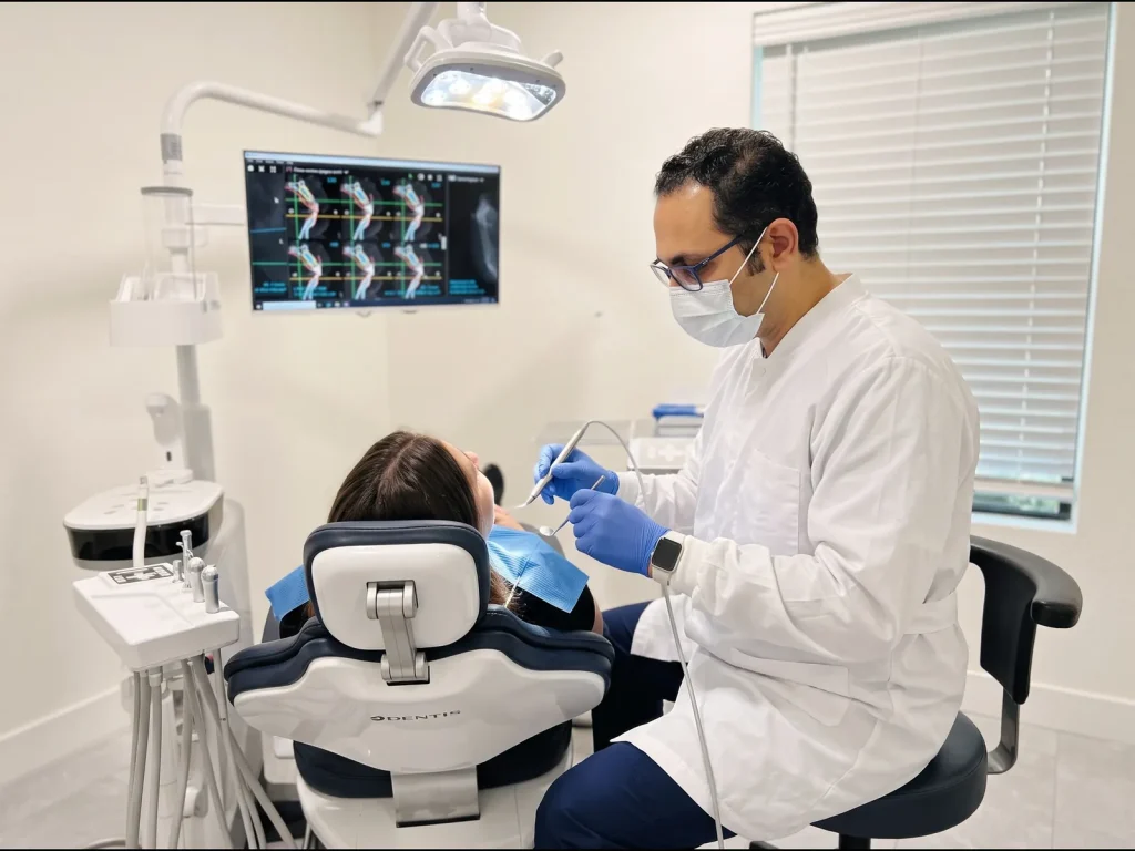 Dr. Walied Eldomiaty using a 3D implant planning scan on the monitor during a procedure at Aloha Dental Specialty Center